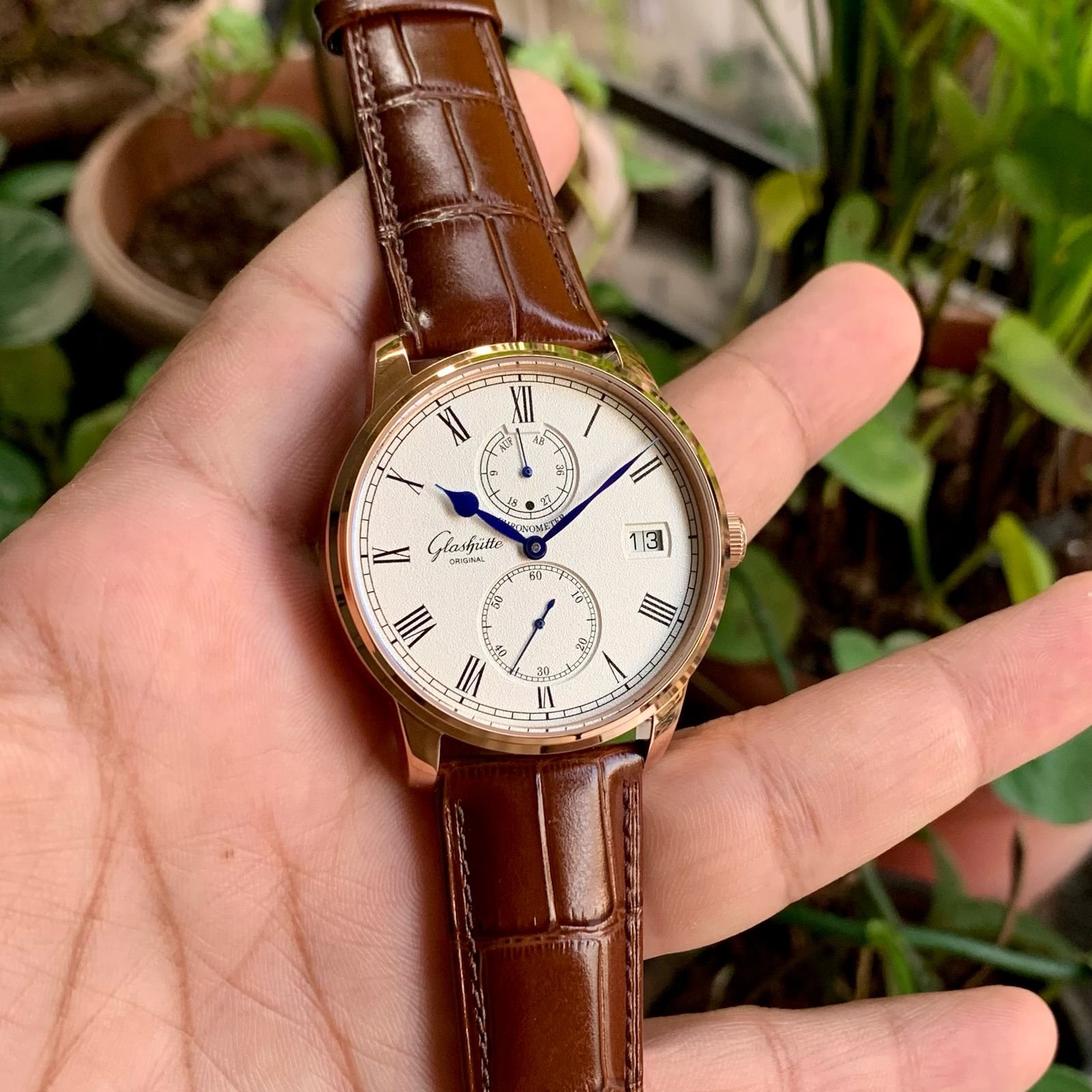 white dial watch with brown leather strap